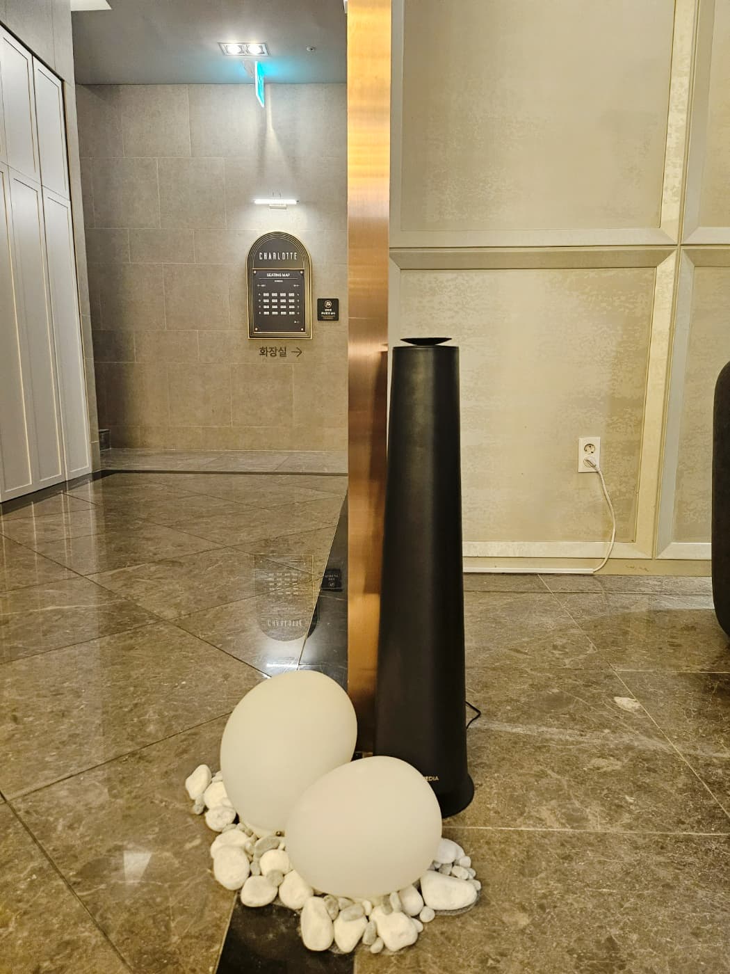 샤롯데 라운지 거울 옆에 배치된 검정색 Scent Tower