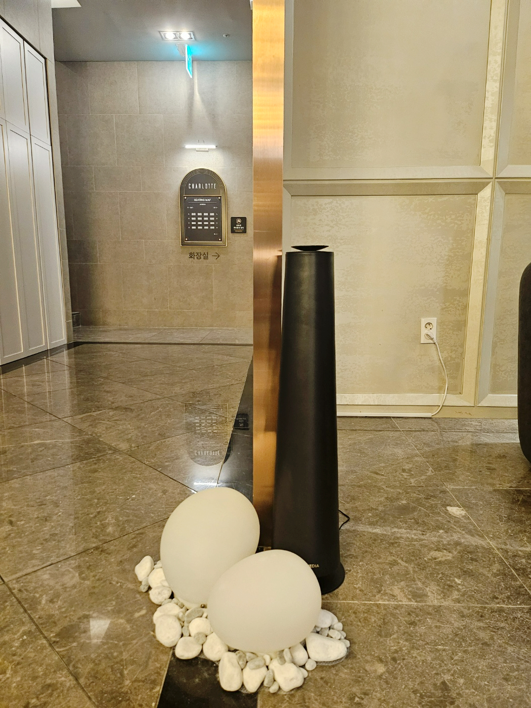 샤롯데 라운지 거울 옆에 배치된 검정색 Scent Tower