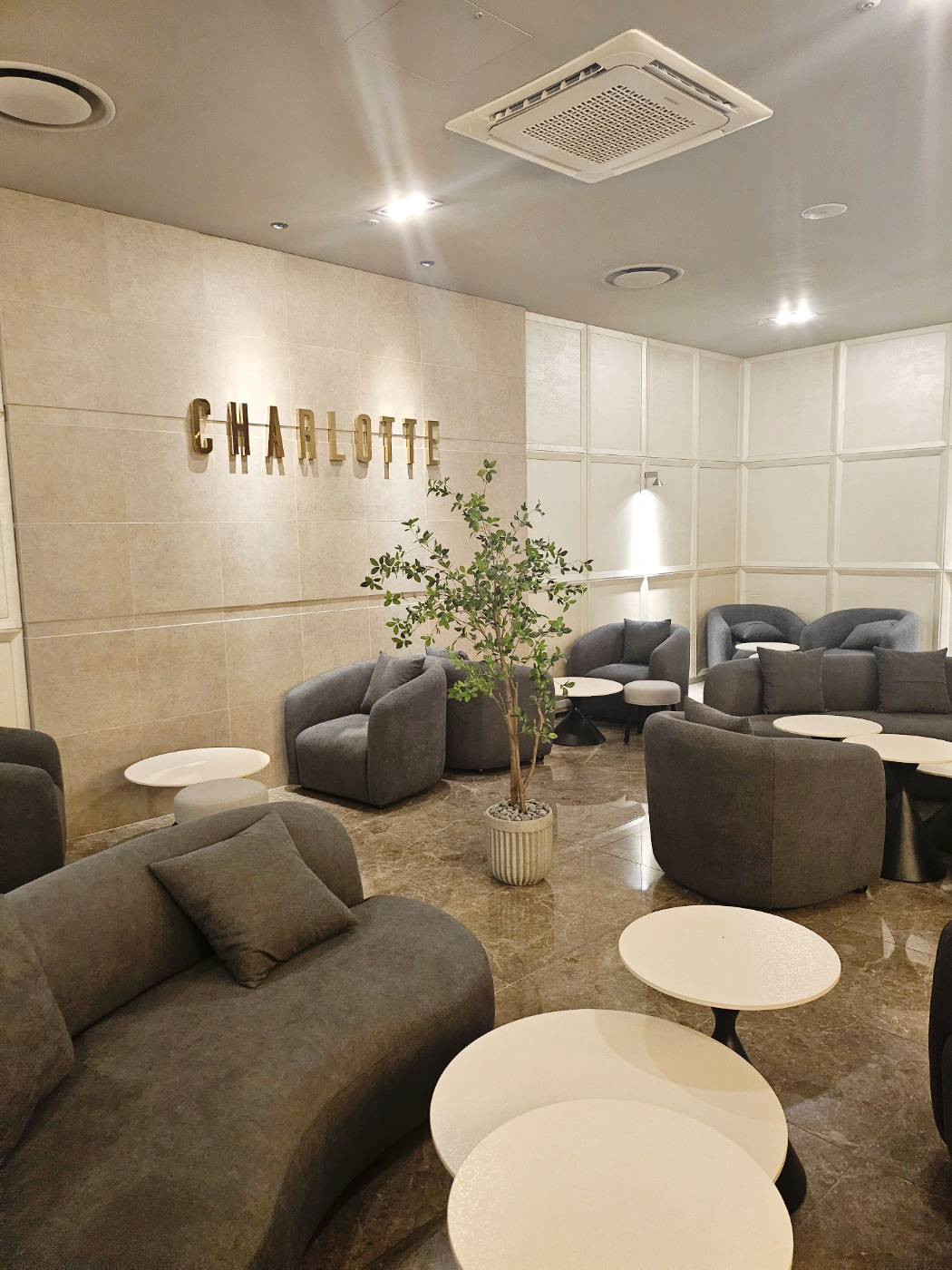 샤롯데 라운지 전경, 소파와 CHARLOTTE 벽면 사인